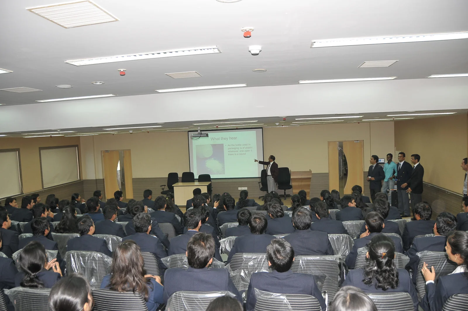 Management students alsong with profesor giving presentation srbs